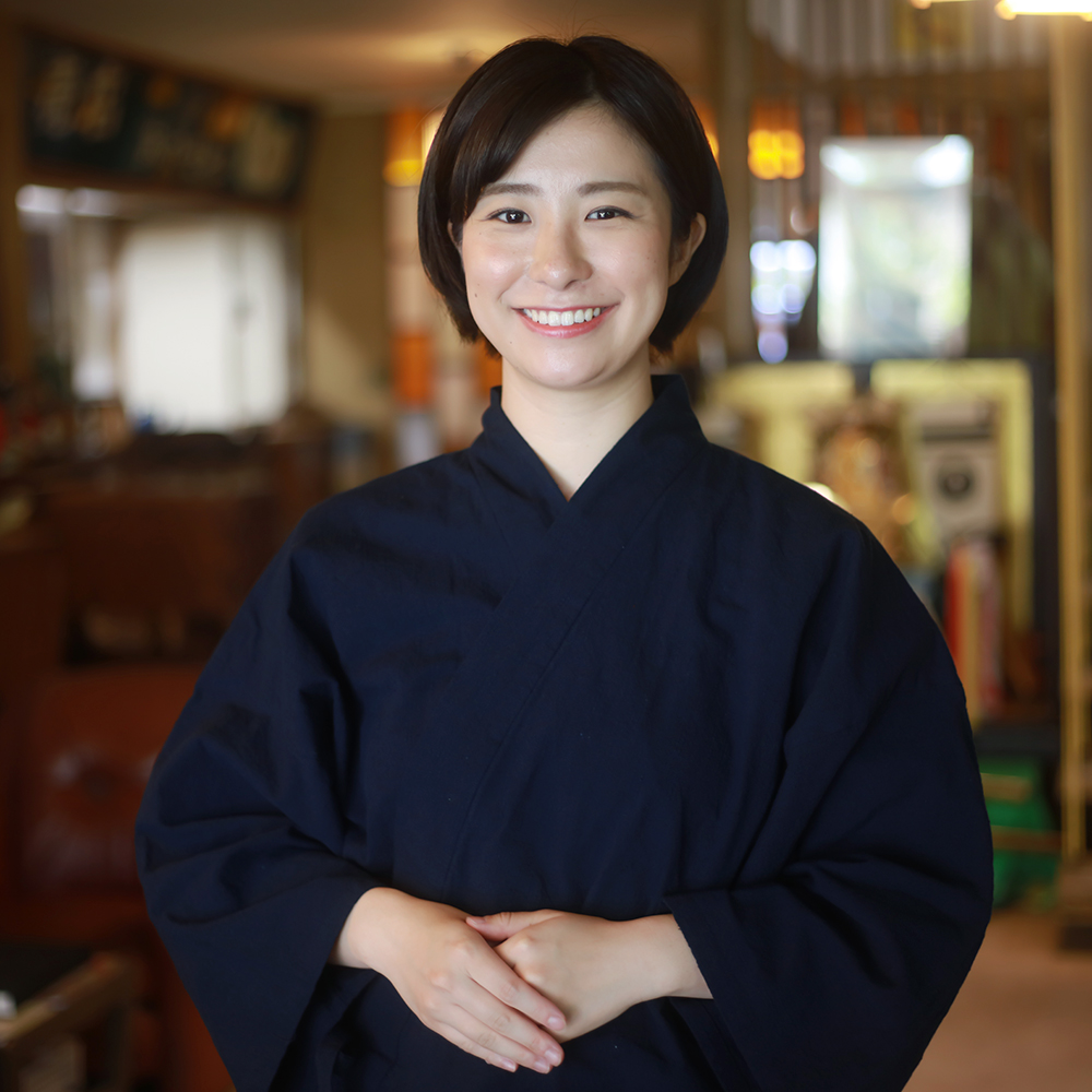 笑顔でお客様を出迎える女性の写真